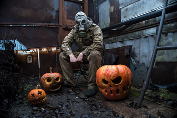 a man in a gas mask with orange halloween pumpkins celebrates the holiday