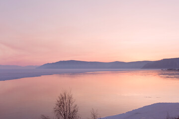 Beautiful sunset on frozen lake Baikal. Winter landscape.