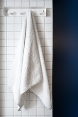 Fototapeta premium Dry terry towel hanging on hook in bathroom