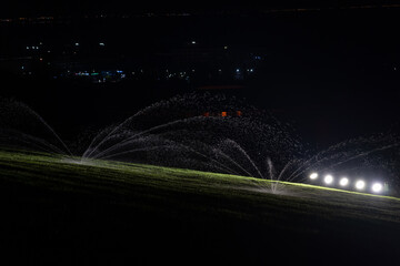 Automatic lawn sprinkler irrigation system that works in green park, watering lawn at night