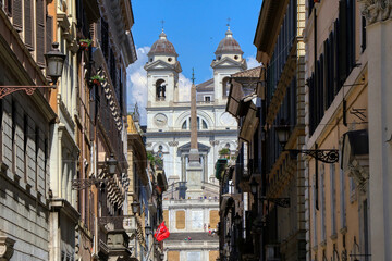 The facade of the Trinità dei Monti church in Piazza di Spagna seen from the famous Via Condotti. Rome Italy