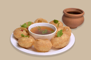 Delicious north and south indian street food pani puri gol gappa with tamarind water served in white plate and mud pot with potato and chickpeas - obrazy, fototapety, plakaty