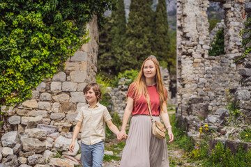 Mom and son tourists walks through the old town of Bar in Montenegro. Happy tourist walks in the...