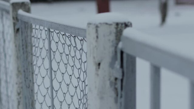 Protective fence with a metal mesh netting against the background of snow in winter, windstorm