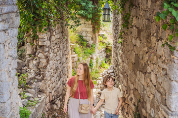 Obraz na płótnie Canvas Mom and son tourists walks through the old town of Bar in Montenegro. Happy tourist walks in the mountains. Suburbs of the city of Bar, Montenegro, Balkans. Beautiful nature and landscape