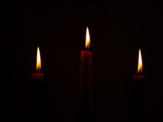 Burning red candles. Burning candles on a dark background.