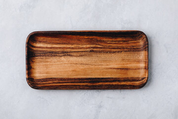 Wooden tray. Empty wooden tray, plate, cutting board on gray stone concrete background, top view.