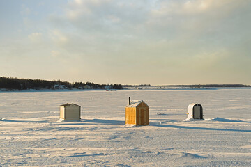 Ice fishing on a frozen harbor in rural Prince Edward Island, Canada. © V. J. Matthew