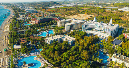 scenic drone shot of luxury hotels near the sea, pools and palm trees, Okurcalar, Turkey. High...