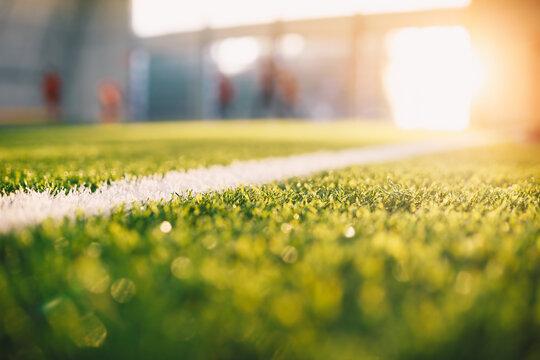 Sunrise at Soccer Football Pitch. Close-up Image of Football Field White Sideline. Sports Players Kicking Training Match in Blurred Background