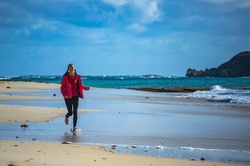 happy girl walks on the famous stingray beach in hamelin bay, near margaret river in western australia, fooling around while walking on the beach