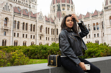 Happy black woman student enjoying great view of the Parliament building in Budapest city, travel...