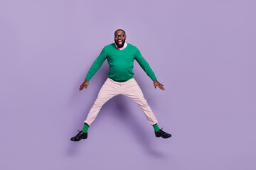 Fototapeta na wymiar Full size photo of active cheerful overjoyed young man gentleman jumping up in excitement isolated on purple color background