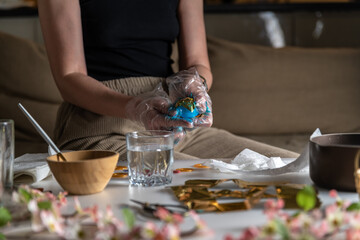 woman at home in the kitchen dyes eggs for Easter