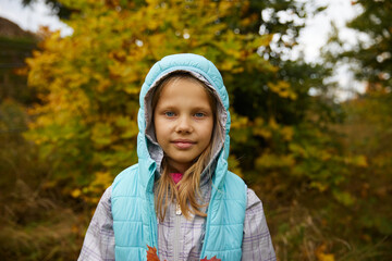 Cute little girl closes her eyes with bright fallen leaves