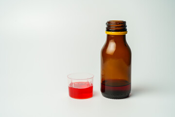 health concept, medicine and medicine - medicine bottle or syrup and antipyretic spoon