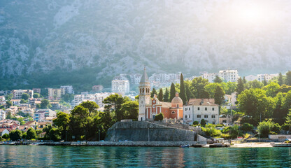 Beautiful city with church in Adriatic sea in Montenegro with mountain view. Scenic town with nature landscapes