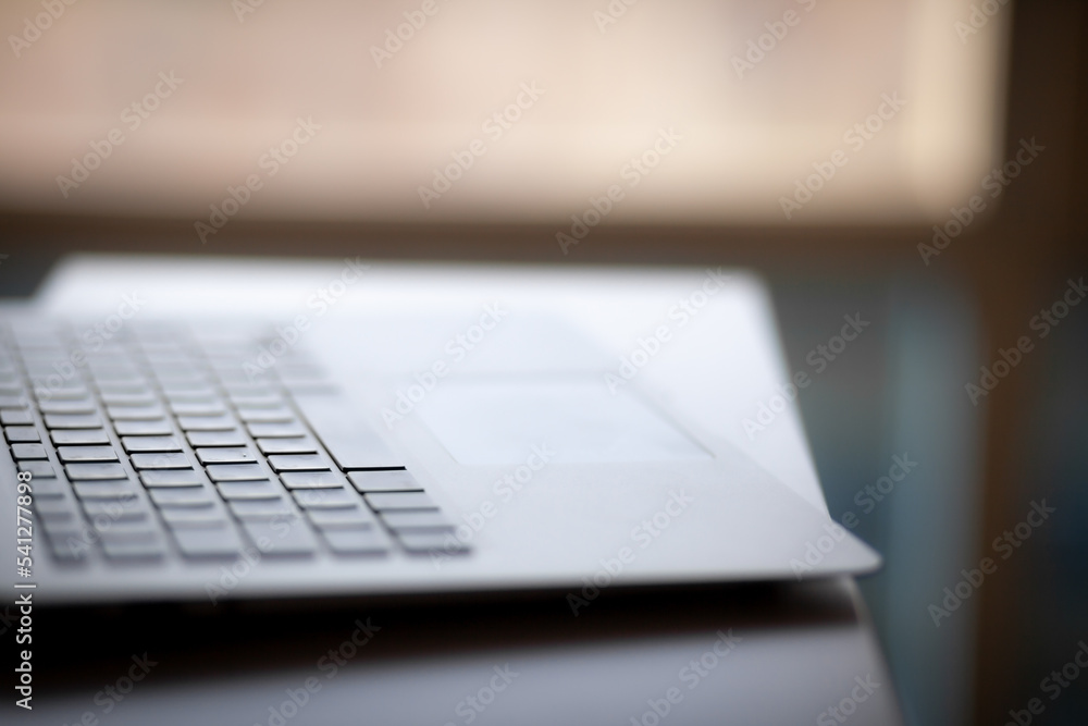 Poster close-up of the keyboard of an open laptop ready to work on the table. side view, selective focus on