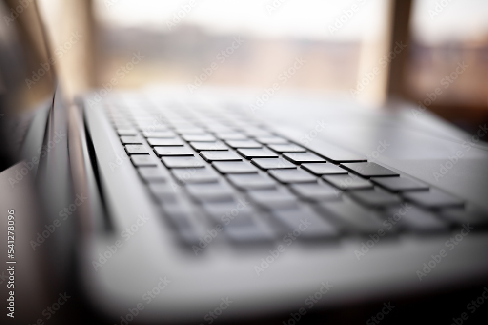 Poster close-up of the keyboard of an open laptop ready to work on the table. side view, selective focus on