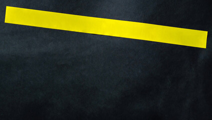 Yellow tape stripe with place for your text on a dark background. Warning and danger concept.