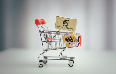 Shopping online. cardboard box with a shopping cart logo in a trolley on a laptop keyboard. Shopping service on The online web. offers home delivery..