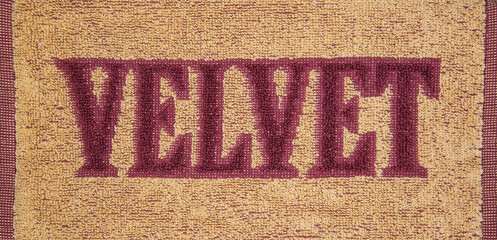 Fragment of a terry towel with the inscription Velvet - obrazy, fototapety, plakaty