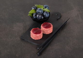 Two Small plum mousse cream cakes of cylindrical shape with tourbillon jelly, sprinkled with...