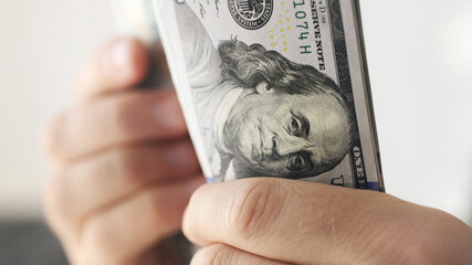 Man counting american dollars banknotes, close up view