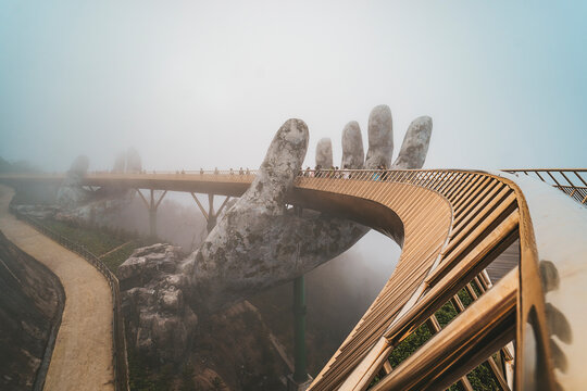 Ba Na Hill mountain resort, Danang city, Vietnam. The Golden Bridge is lifted by two giant hands in the tourist resort on Ba Na Hill in a foggy day at Danang, Vietnam