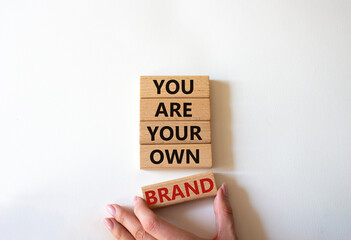 You are your own brand symbol. Wooden blocks with words You are your own brand. Beautiful white background. Businessman hand. Business and You are your own brand concept. Copy space.