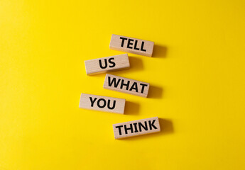 Tell us what you think symbol. Wooden blocks with words Tell us what you think. Beautiful yellow...
