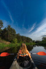 Woman doing kayak in a river with forest