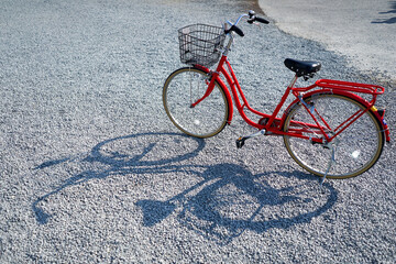Plakat Red blue colour city bicycle park at the rocky floor with nice bicycle shadow on the left