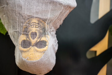 Closeup orange skull hang with white cloak. Halloween decoration