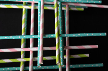 Multicolored cocktail straws on a black background