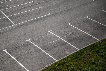 Empty parking lot, white road marking lines go over gray asphalt