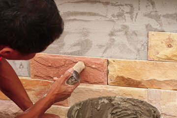 Proffesional tiler wall tile installation. Workers laying tiles wall. DIY, Do it yourself concept. House improvement. Repair renovation work. Selective focus.	
