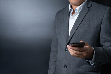 Close up businessman pushing, touching on smartphone with black and gray background