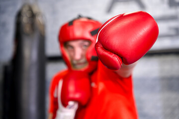 Elderly senior retired healthy athletic old man is fighting, training at gym, boxing in gloves,...