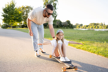 Happy little girl on skateboard outdoor. Child practicing outside. - Powered by Adobe