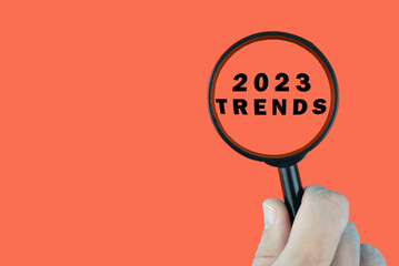 Focused on trend for next year 2023 concept. Words 2023 trends under magnifying glass. Card design.