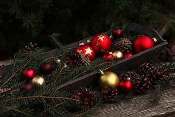Dekoracja bożonarodzeniowa z bombkami, szyszkami i zieloną gałązką