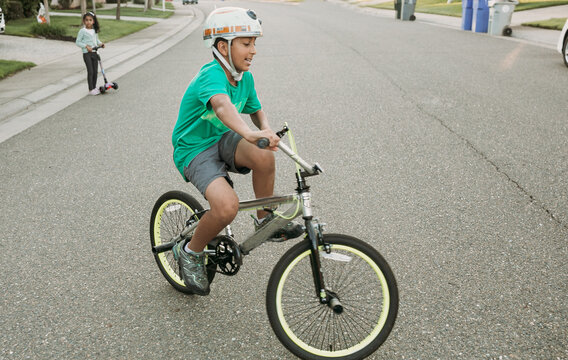 A boy riding his bike in the neighborhood 