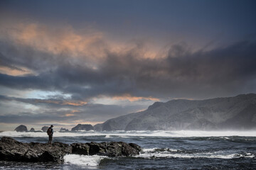 Persona en la costa mirando hacia el océano 
