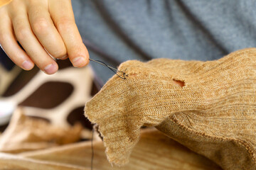 Mending clothes. Concept of mending and repairing clothes. Creative sustainable fashion and recycling.