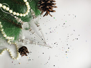Fir branches, Christmas toys, garlands on a white background with confetti. Christmas background for a postcard, banner, site.