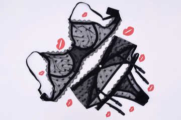 Lace sexy black women's underwear, with red kisses on a light background flat lay top.