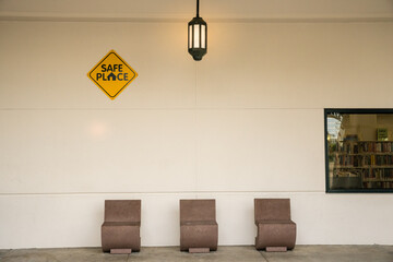 Sign at public building reading "Safe Place" with 3 chairs