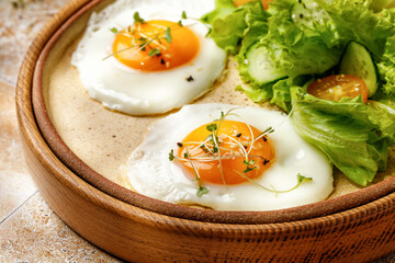 Fried eggs with micro greens, lettuce and cherry tomatoes on beige background, tile, in sunny...
