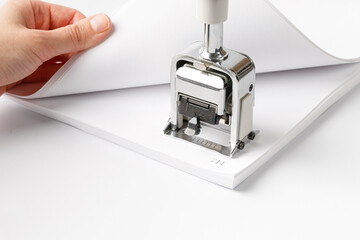 Woman stamping page numbers. To number the pages, automatic numbering system for paper. Office supplies, stationery.